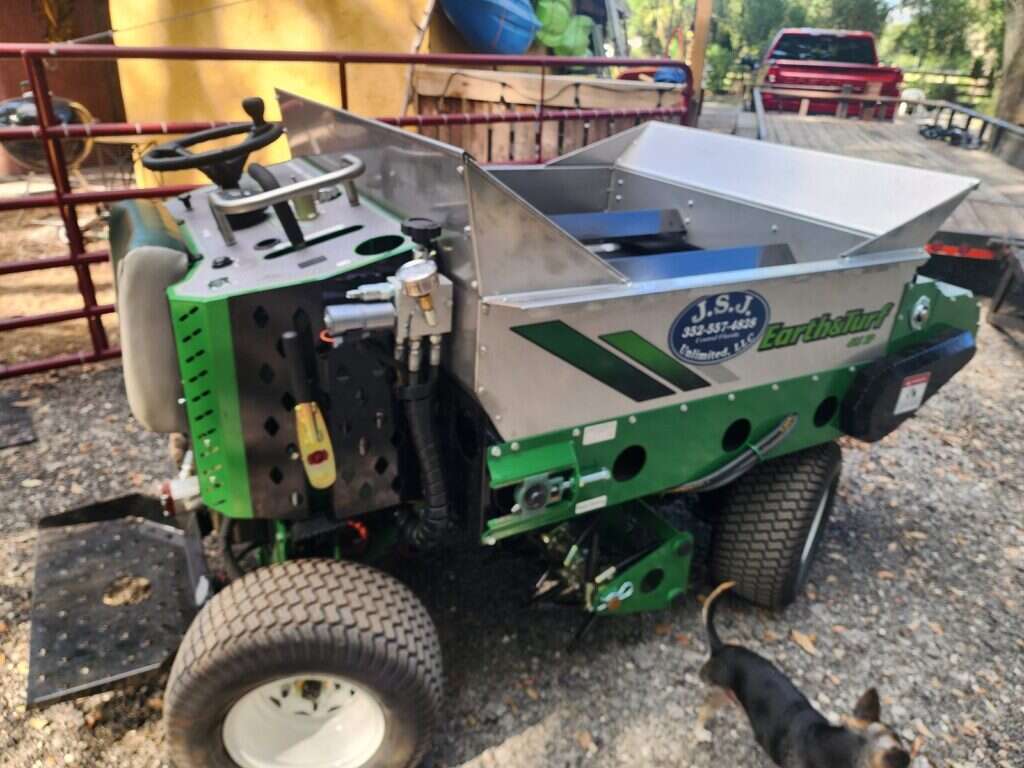 Earth and Turf 415SP stand-on topdresser branded for Independent Aeration Services